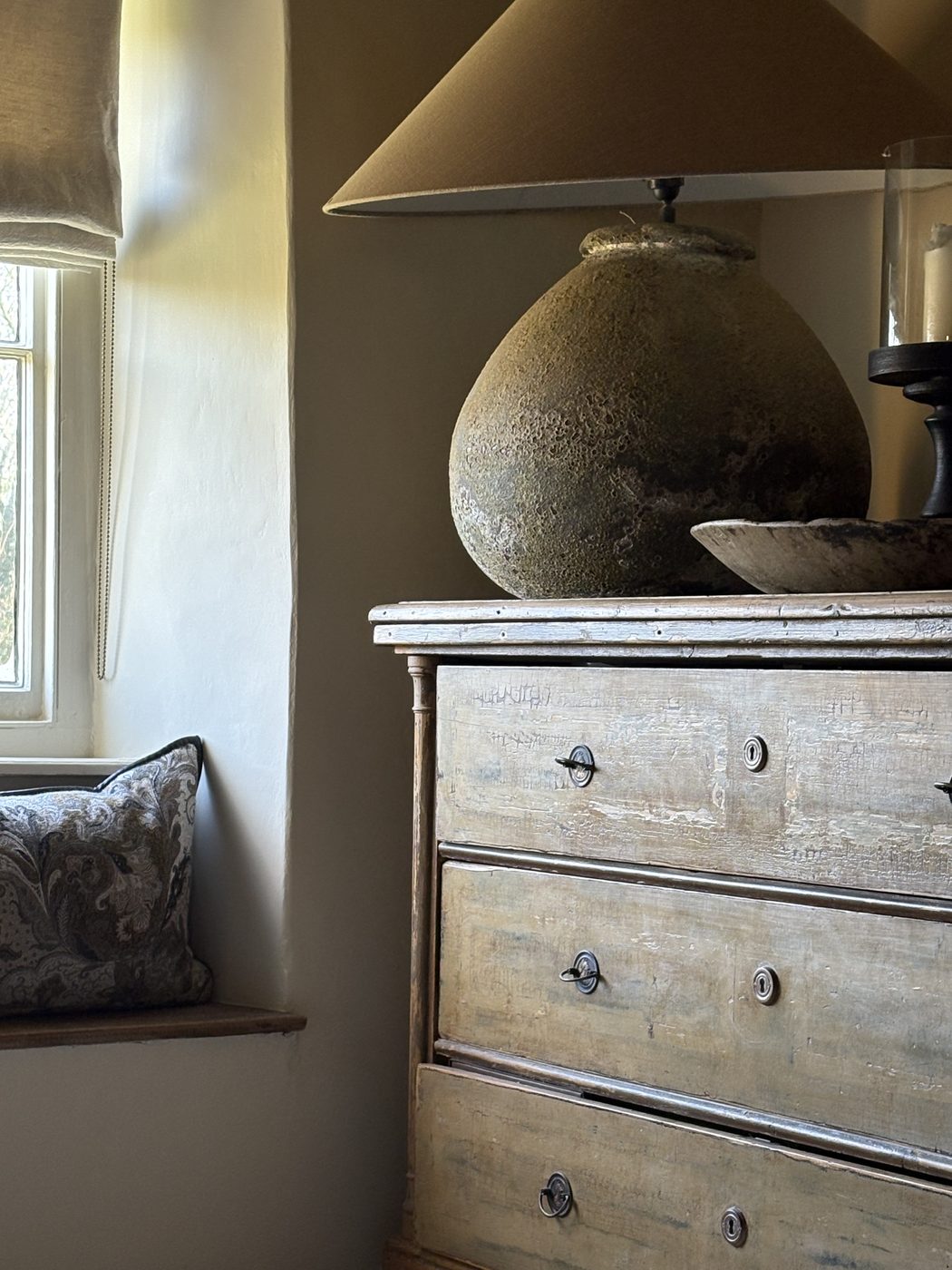 Lapwing House — Hungarian chest of drawers in original ochre and green paint, with a weathered vessel lamp
