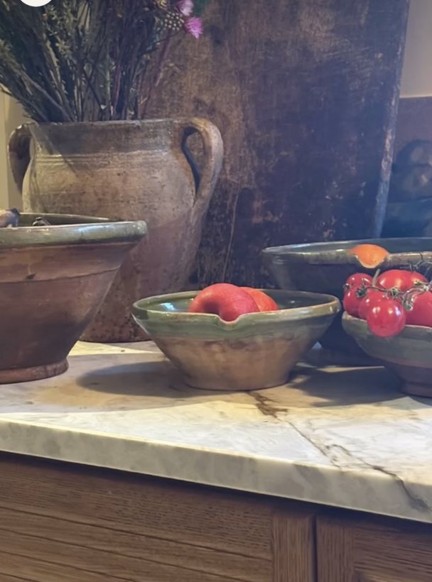 Lapwing House — antique green-glazed bowls and an olive jar on the marble, over the reeded oak