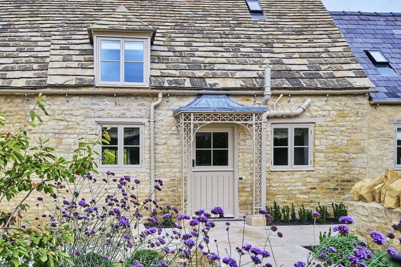 The Shambles — Bulwick ironstone cottage, decorative iron porch and Collyweston slate roof